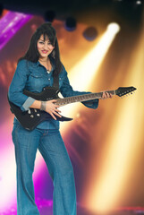 Fototapeta premium Woman Playing Guitar with Lights Background