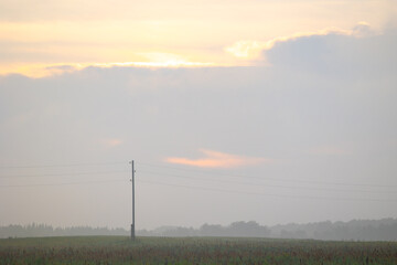 A beautiful minimalist landscape with colorful sunrise skies. Bright summer scenery of rural Latvia, Northern Europe.