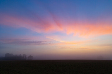 A beautiful minimalist landscape with colorful sunrise skies. Bright summer scenery of rural Latvia, Northern Europe.