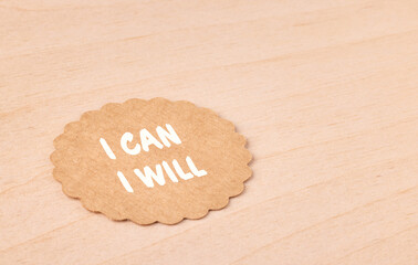I can I will, motivational text message on craft paper and wooden background, self-empowerment and...