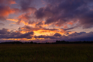 A beautiful summer sunrise in rural Latvia. Bright morning sky with dark foreground.