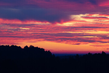 A beautiful summer sunrise in rural Latvia. Bright morning sky with dark foreground.