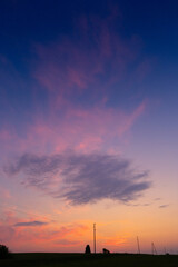 A beautiful summer sunrise in rural Latvia. Bright morning sky with dark foreground.