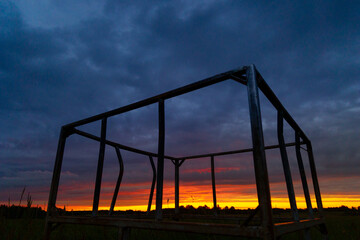 A beautiful summer sunrise in rural Latvia. Bright morning sky with dark foreground.