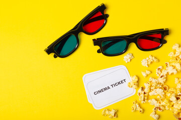 Tasty popcorn in buckets and cold cola drinks with cinema tickets, movie clapper and 3D eyeglasses...