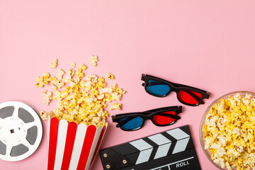Tasty popcorn in buckets and cold cola drinks with cinema tickets, movie clapper and 3D eyeglasses...