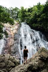 Stunning view of a girl in front of Na Muang Waterfall, Koh Samui, Thailand.
