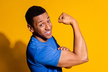 Photo portrait of attractive young man show biceps boast dressed stylish blue clothes isolated on...