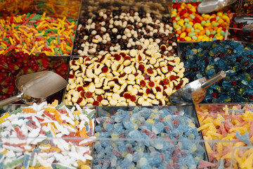 Colorful sweets and gummy candies are displayed at the market, providing a vibrant selection for customers