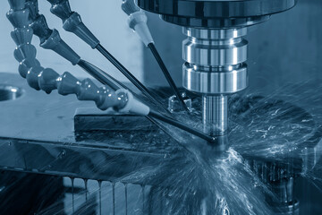 The CNC milling machine rough cutting the mold parts with liquid coolant method.
