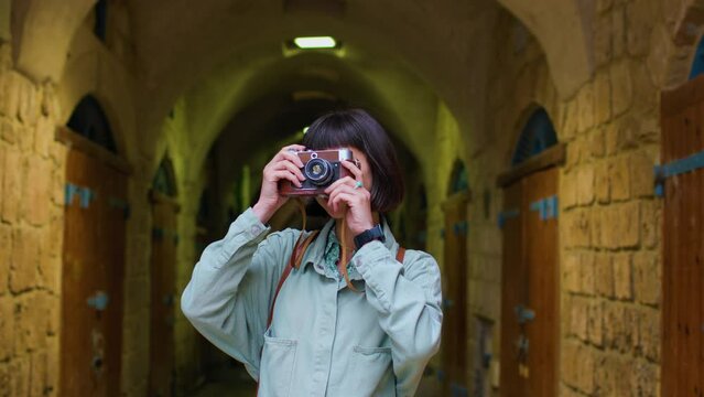 young girl with a camera. Fashionable and attractive beautiful woman with analog film camera takes photos during sunset, 
creates content.  travel and vacation.