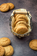 Oatmeal cookies in a basket on a dark background. Healthy diet.