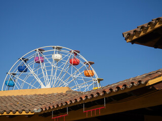 Ferris wheel peeking out from behind the houses