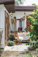 Picturesque courtyard with wooden furniture, gramophone, straw hats and various utensils for working in the garden. Nostalgic motif. A series of lifestyle photographs.