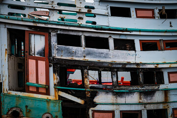 Wreck wooden fishery boat with green  and white color. abandoned fishing boat.