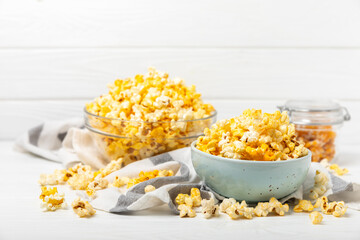 Tasty popcorn on wooden background. Cinema and entertainment concept. Movie night with popcorn.Cheese and caramel popcorn. Delicious appetizer, snack. Place for text. Copy space.Banner
