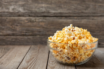 Tasty popcorn on wooden background. Cinema and entertainment concept. Movie night with...