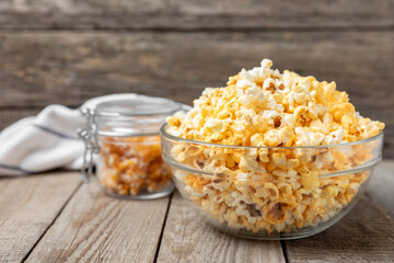 Tasty popcorn on wooden background. Cinema and entertainment concept. Movie night with popcorn.Cheese and caramel popcorn. Delicious appetizer, snack. Place for text. Copy space.Banner