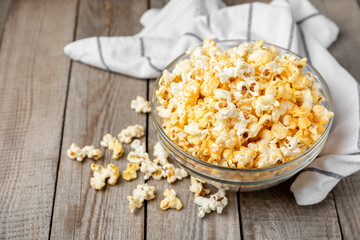 Tasty popcorn on wooden background. Cinema and entertainment concept. Movie night with popcorn.Cheese and caramel popcorn. Delicious appetizer, snack. Place for text. Copy space.Banner