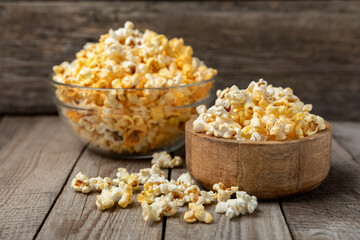 Tasty popcorn on wooden background. Cinema and entertainment concept. Movie night with popcorn.Cheese and caramel popcorn. Delicious appetizer, snack. Place for text. Copy space.Banner