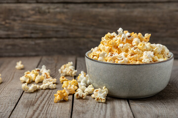 Tasty popcorn on wooden background. Cinema and entertainment concept. Movie night with popcorn.Cheese and caramel popcorn. Delicious appetizer, snack. Place for text. Copy space.Banner