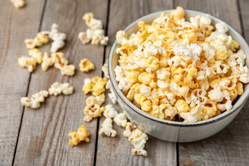 Tasty popcorn on wooden background. Cinema and entertainment concept. Movie night with popcorn.Cheese and caramel popcorn. Delicious appetizer, snack. Place for text. Copy space.Banner