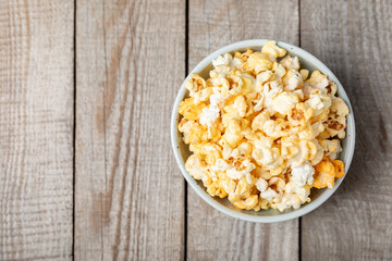 Tasty popcorn on wooden background. Cinema and entertainment concept. Movie night with popcorn.Cheese and caramel popcorn. Delicious appetizer, snack. Place for text. Copy space.Banner