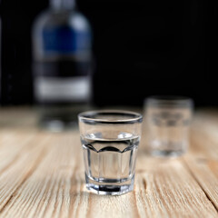 vodka in a glass on a wooden table close-up. alcohol