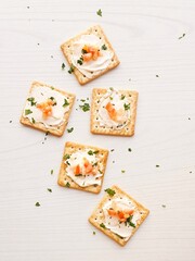 Cream cracker biscuit with tomato mayonnaise and parsley on a  white wooden background