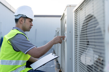Asian maintenance engineer works on the roof of factory. contractor inspect compressor system and...