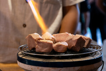 Chef cooking a sous vide beef tongue on fire.
