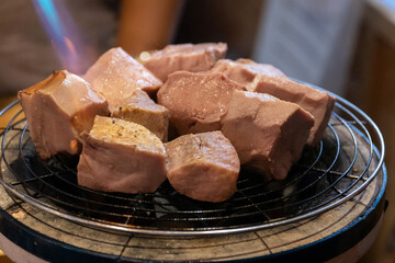 Chef cooking a sous vide beef tongue on fire.