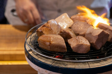 Chef cooking a sous vide beef tongue on fire.