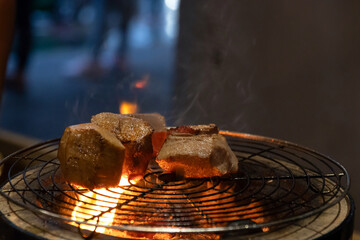 Chef cooking a sous vide beef tongue on fire.