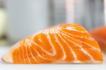 Close up of fresh salmon on white cutting board.