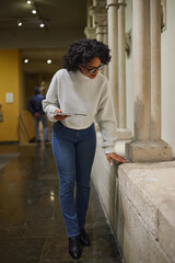 Woman visitor in the historical museum looking at art object.