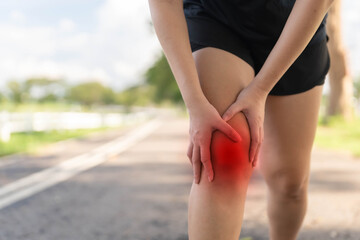 A woman is hurting her knee after running. Health problem concept, osteoarthritis problem. Running hard until injured.