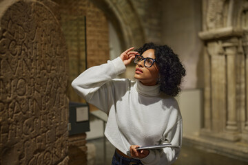 Woman visitor in the historical museum looking at art object.