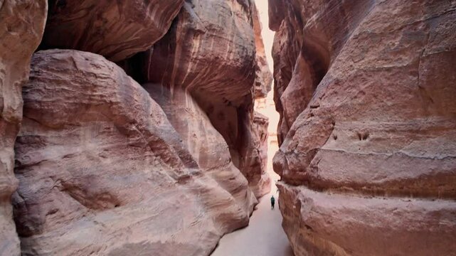 aerial view of tourist woman walking to The Treasury, Al Khazneh, is one of the most elaborate temples in the ancient Jordanian city of Petra in Jordan, carved into the sandstone cliff face