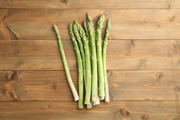 Fresh green asparagus stems on wooden table, top view