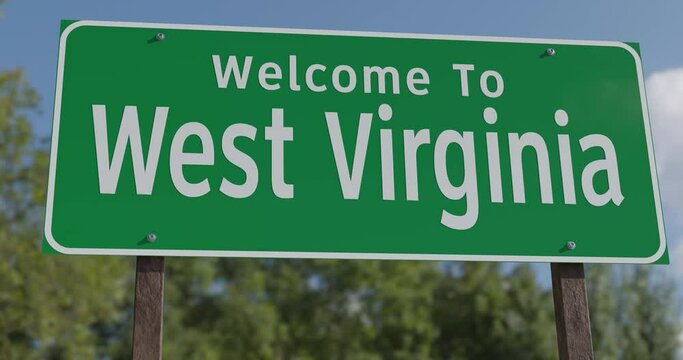 Driving By A Welcome To West Virginia Green Road Sign Against a Blue Sky and Clouds.
