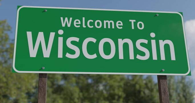 Driving By A Welcome To Wisconsin Green Road Sign Against a Blue Sky and Clouds.
