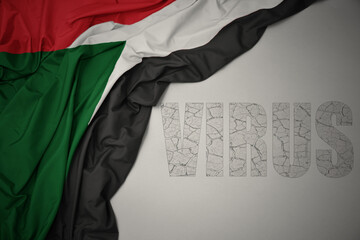 waving colorful national flag of sudan on a gray background with text virus .