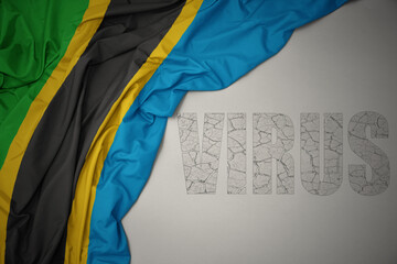 waving colorful national flag of tanzania on a gray background with text virus .