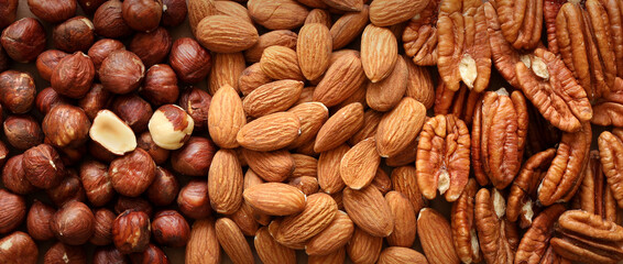 Creative layout made of hazelnut, almond, pecan nuts. Flat lay. Food concept. Nut pattern concept. Macro image.