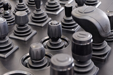 Various control sticks on a black dashboard © Sergey Skleznev
