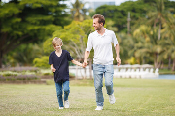 Caucasian white man and son running and relaxing at the park.