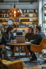 Three people are sitting around a table in a library, working on a project