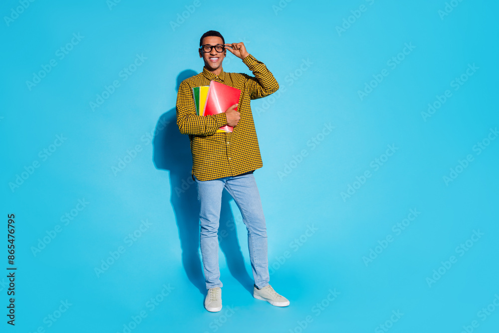 Wall mural Full length photo of handsome young guy university hold copybooks dressed stylish plaid garment isolated on blue color background