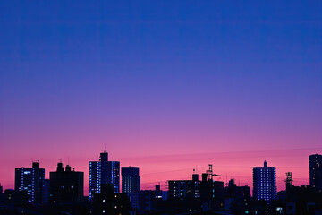 Fototapeta premium a city skyline with the sun setting behind it